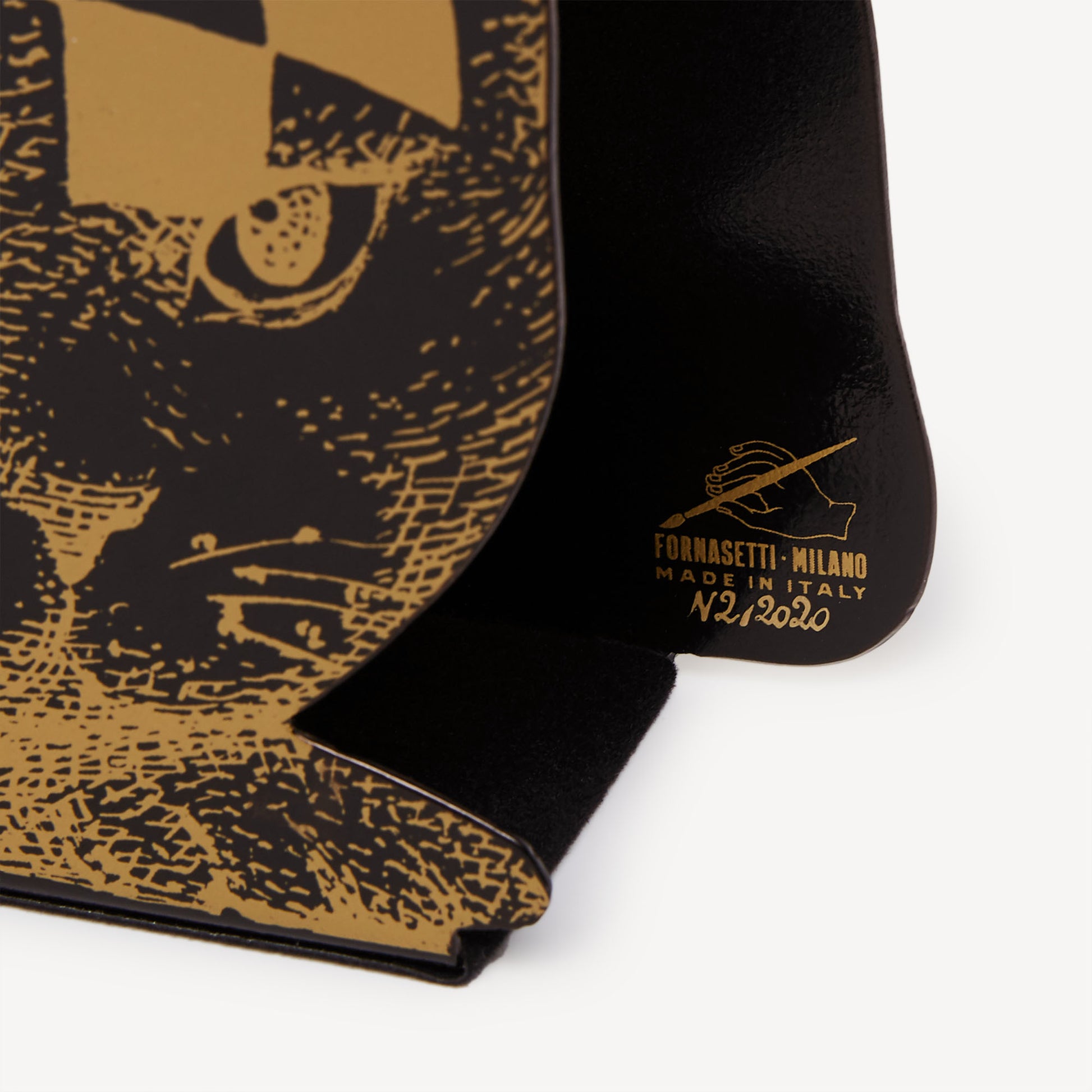 Gold and black cat-pattern magazine rack close-up corner showing label