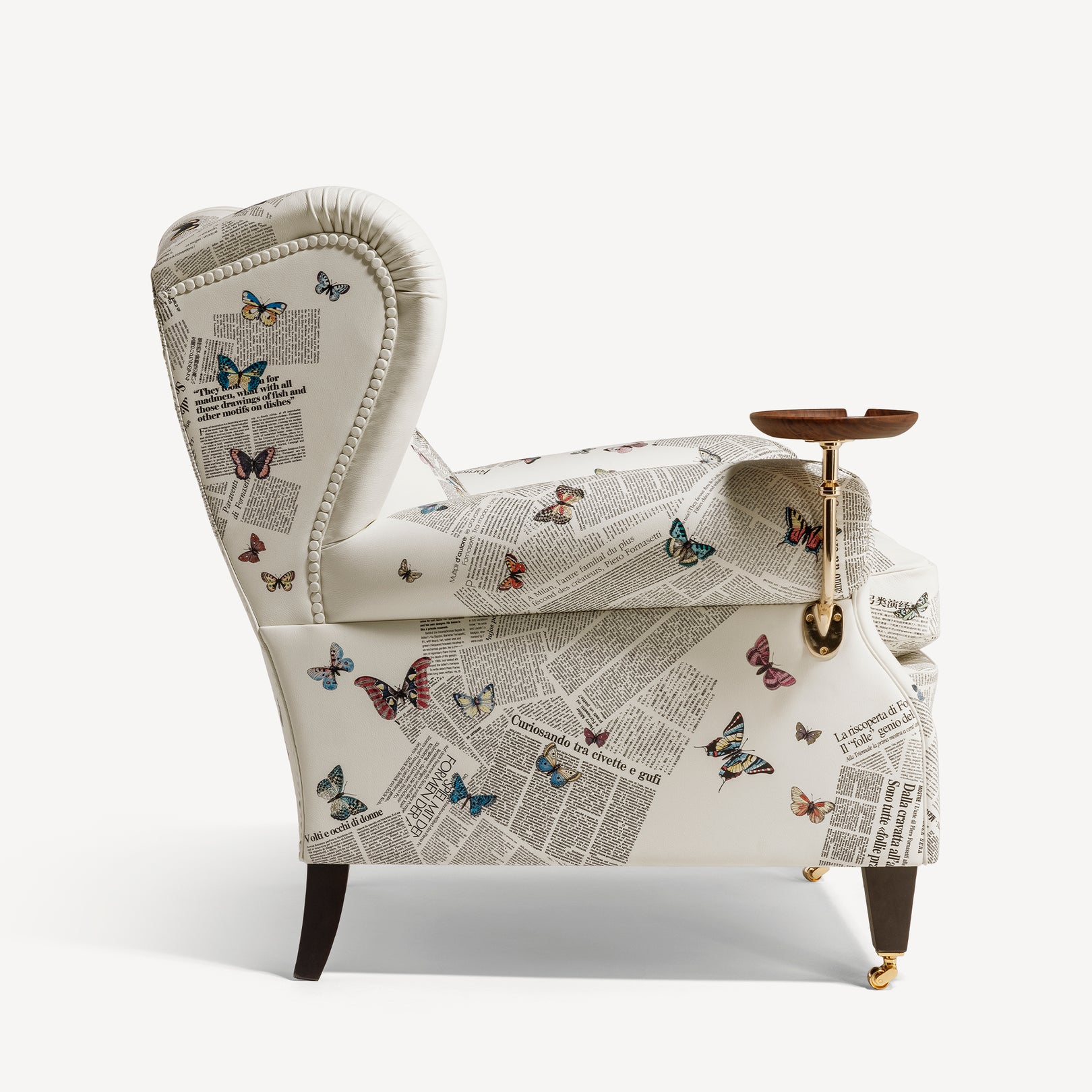 Armchair covered in newspaper print with butterflies, side view
