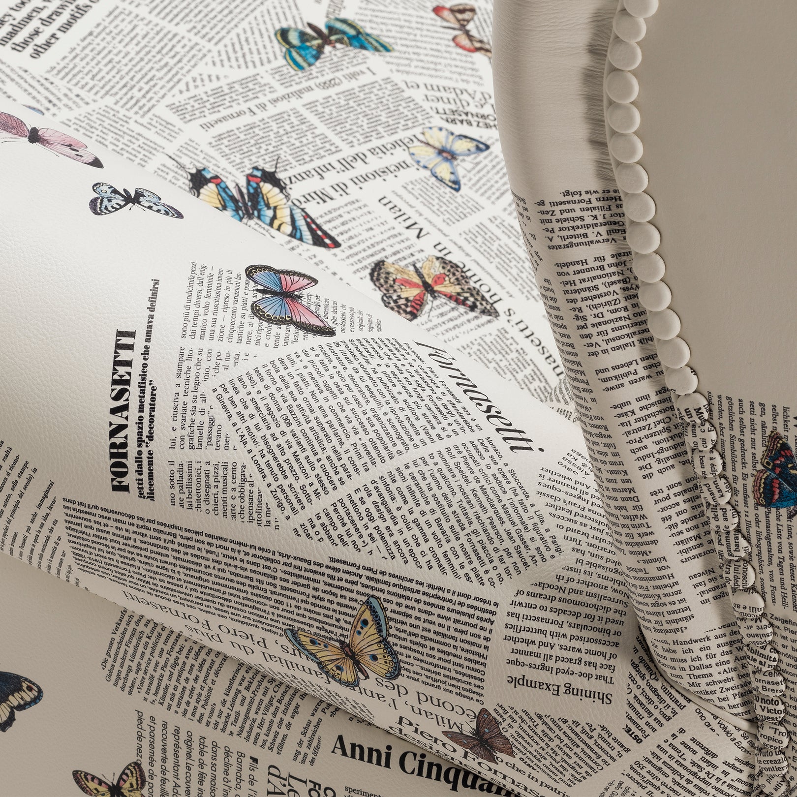 Close-up of newspaper print and butterflies on chair fabric