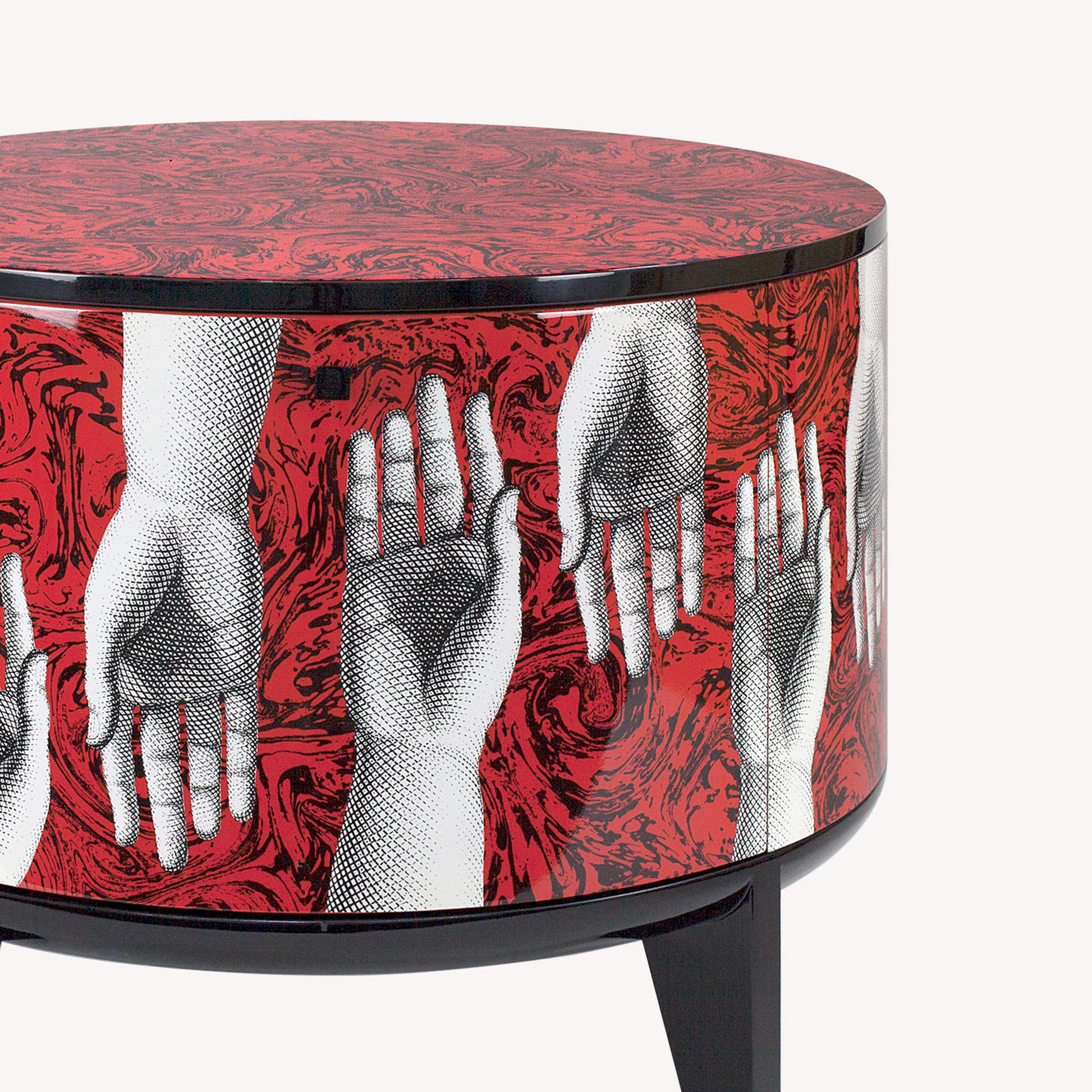 Round side table with red and black graphic pattern of hands